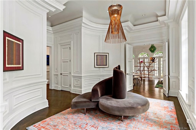 sitting room with ornamental molding and dark parquet flooring