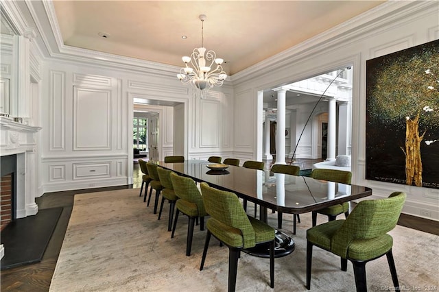 dining area featuring ornamental molding, a chandelier, ornate columns, and dark hardwood / wood-style flooring