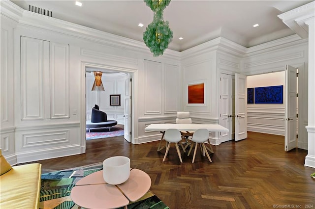 dining space featuring ornate columns, ornamental molding, and dark parquet flooring