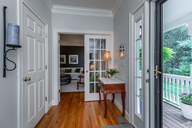 doorway to outside with ornamental molding, french doors, baseboards, and wood finished floors