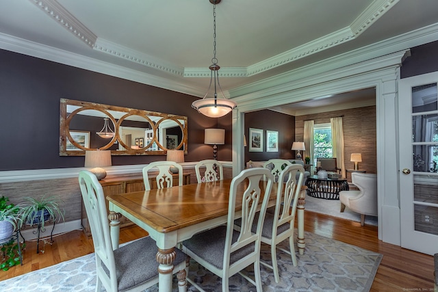 dining area with ornamental molding and wood finished floors