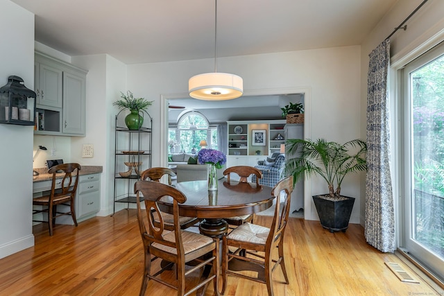 dining space featuring built in study area, visible vents, and light wood-style floors