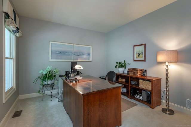 office area with baseboards, visible vents, and light colored carpet