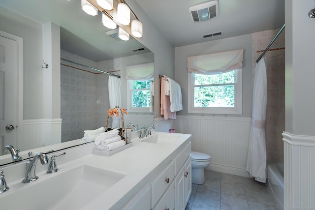 bathroom featuring a wainscoted wall, visible vents, and a sink