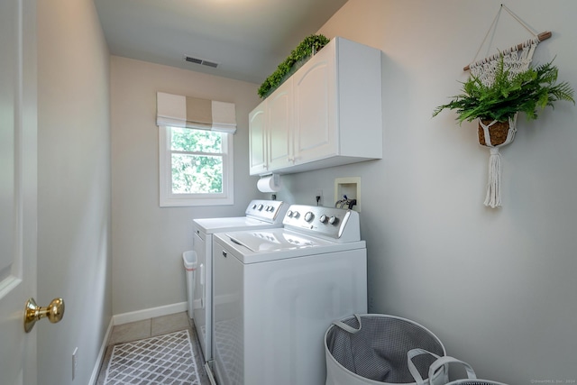 clothes washing area featuring washing machine and clothes dryer, light tile patterned floors, cabinet space, visible vents, and baseboards