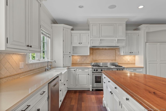 kitchen with white cabinetry, dark hardwood / wood-style flooring, stainless steel appliances, and backsplash