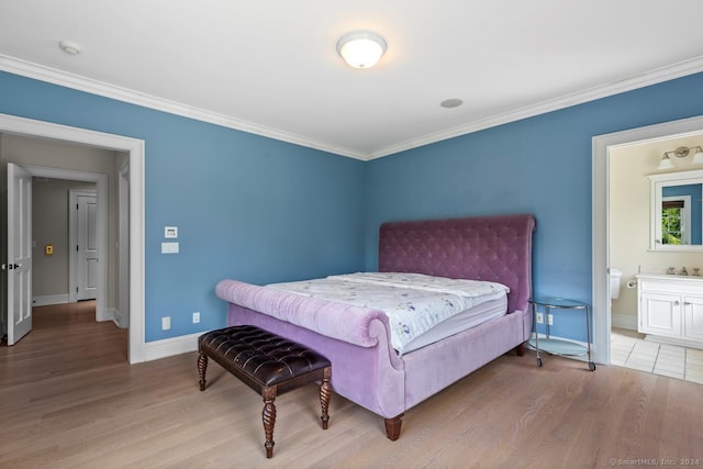 bedroom featuring ornamental molding, connected bathroom, and light hardwood / wood-style floors