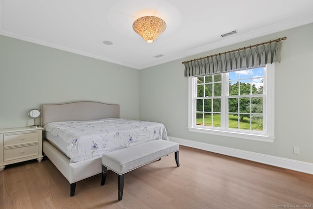 bedroom with hardwood / wood-style flooring and crown molding