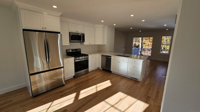 kitchen featuring white cabinetry, sink, kitchen peninsula, appliances with stainless steel finishes, and light hardwood / wood-style flooring