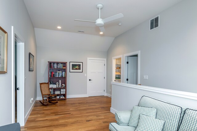 living area with light wood-type flooring, vaulted ceiling, and ceiling fan