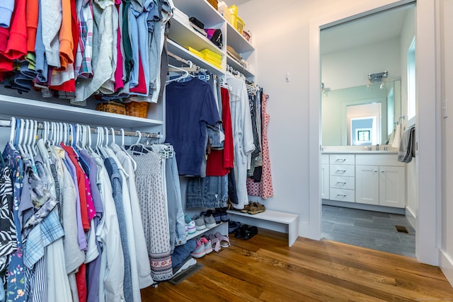 spacious closet with hardwood / wood-style floors and sink