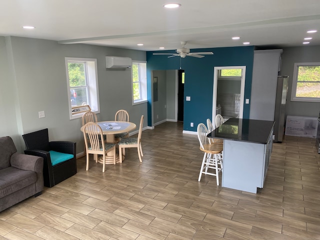 living room featuring ceiling fan, light wood-type flooring, and a wall mounted air conditioner