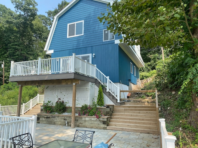 rear view of property featuring a patio and a deck