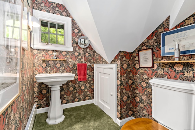 bathroom with lofted ceiling, wallpapered walls, and baseboards