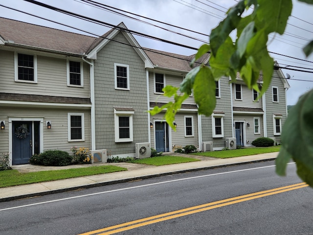 view of front of house featuring a front lawn and ac unit