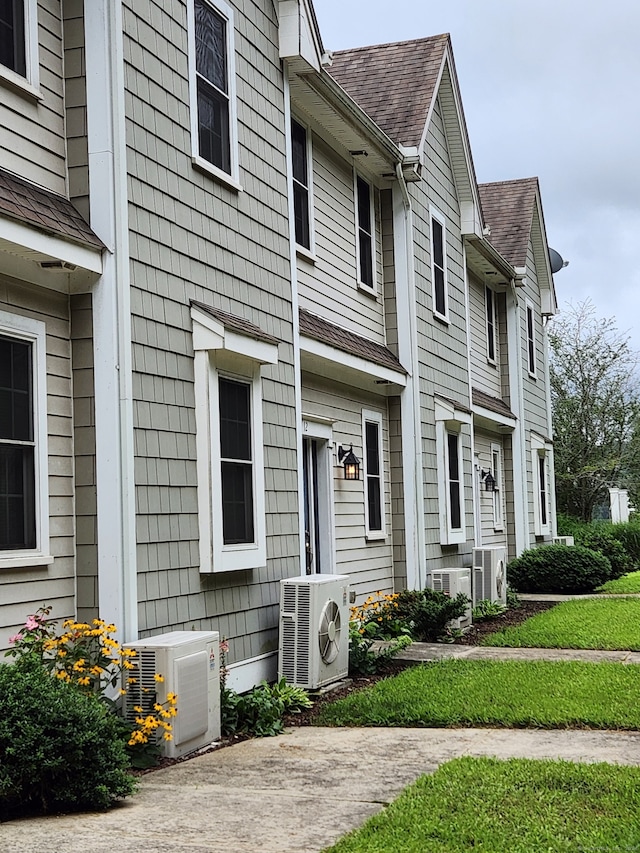 view of front of property featuring ac unit, central AC, and a front yard