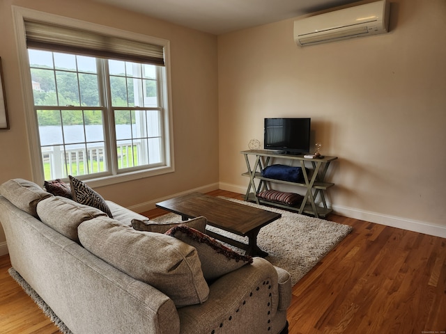 living room featuring hardwood / wood-style flooring and a wall mounted air conditioner