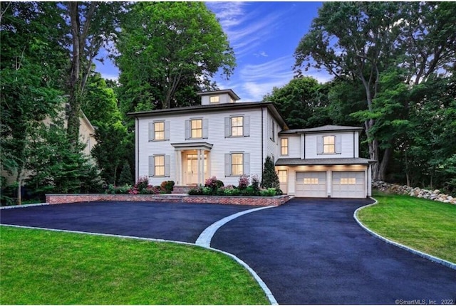 colonial inspired home with a front yard and a garage