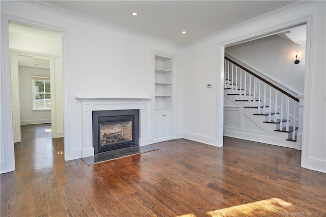 unfurnished living room with dark hardwood / wood-style flooring, ornamental molding, and built in features