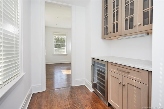 interior space with crown molding, dark hardwood / wood-style floors, wine cooler, and light stone countertops