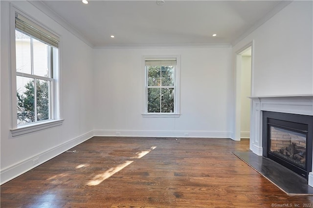 unfurnished living room with dark wood-type flooring, ornamental molding, and a healthy amount of sunlight