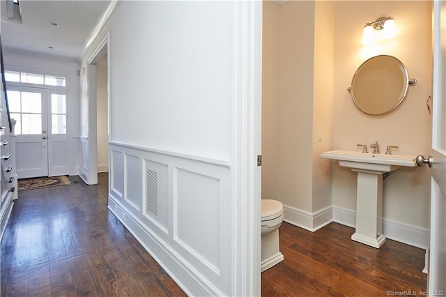 bathroom featuring toilet, ornamental molding, and hardwood / wood-style floors