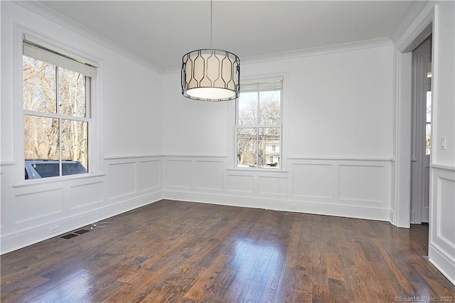 unfurnished dining area featuring ornamental molding, dark hardwood / wood-style flooring, and a healthy amount of sunlight