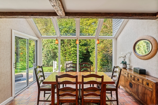 dining area featuring beamed ceiling and a skylight