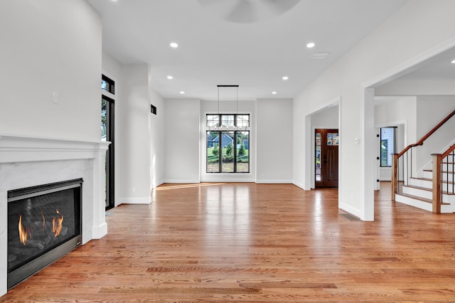 unfurnished living room featuring light wood-type flooring and a premium fireplace