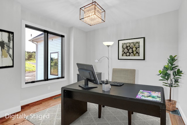 home office featuring a notable chandelier and wood-type flooring