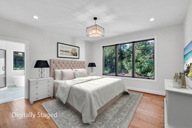 bedroom with ensuite bath and light hardwood / wood-style floors