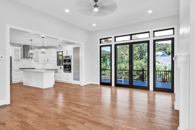 unfurnished living room featuring ceiling fan, light hardwood / wood-style flooring, and a wealth of natural light