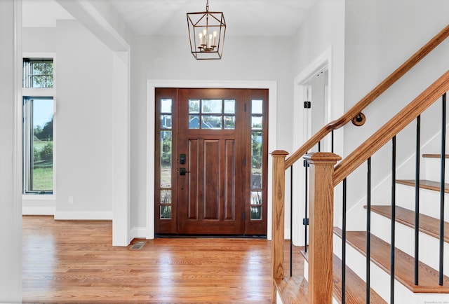 foyer entrance with a notable chandelier and light wood-type flooring