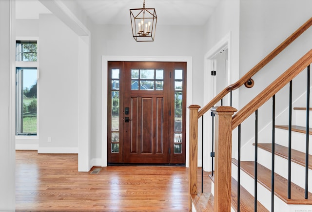 entrance foyer featuring a notable chandelier and light hardwood / wood-style flooring