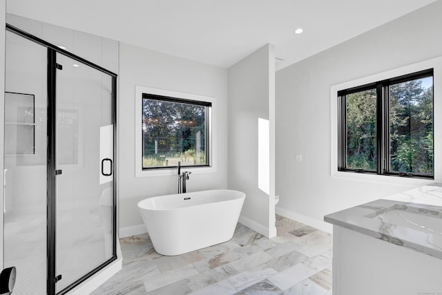 bathroom featuring vanity, a wealth of natural light, and plus walk in shower