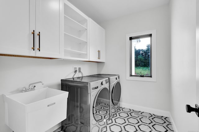 washroom featuring independent washer and dryer, light tile patterned floors, sink, and cabinets