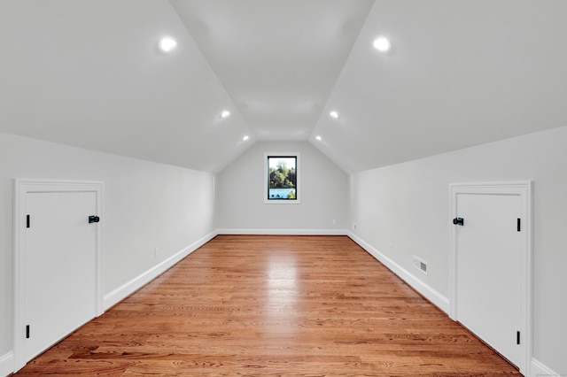 additional living space with lofted ceiling and light wood-type flooring