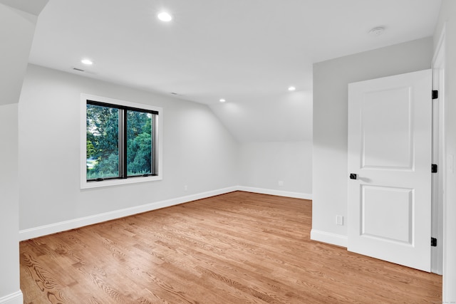 additional living space featuring light hardwood / wood-style flooring and vaulted ceiling