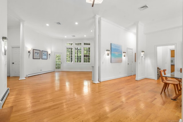 living room with ornamental molding, a baseboard radiator, and light wood-type flooring