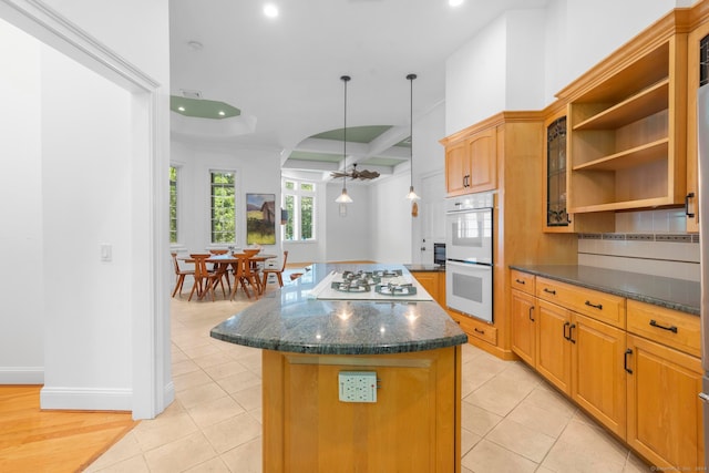 kitchen with light tile patterned flooring, beam ceiling, a center island, and white appliances