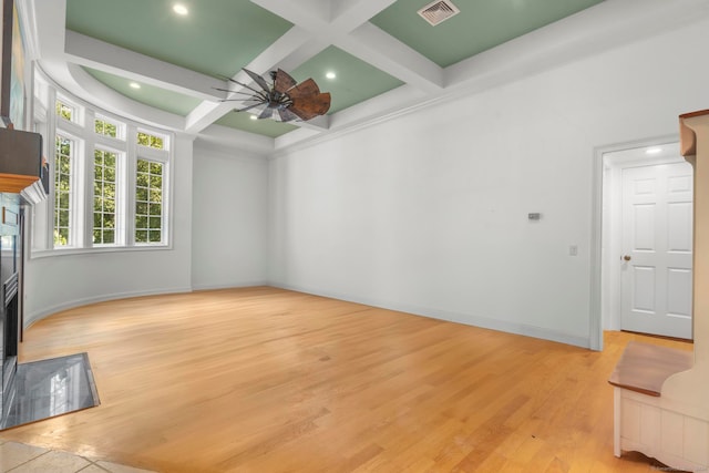 unfurnished living room with light hardwood / wood-style flooring, beam ceiling, coffered ceiling, and ceiling fan