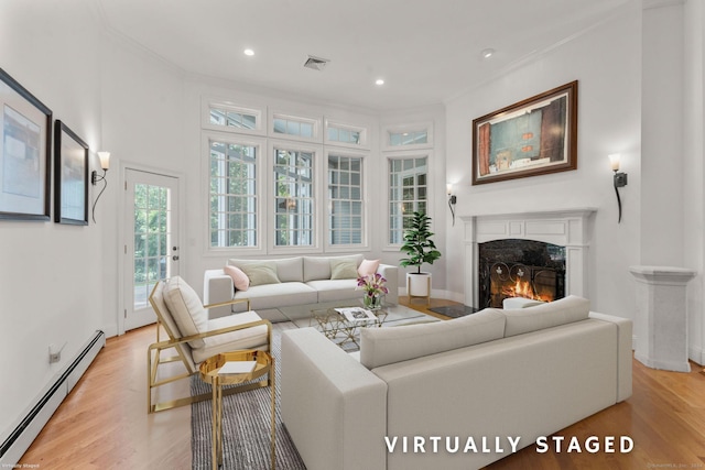 living room with light hardwood / wood-style floors, crown molding, baseboard heating, and a high end fireplace