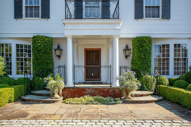 view of exterior entry with a balcony