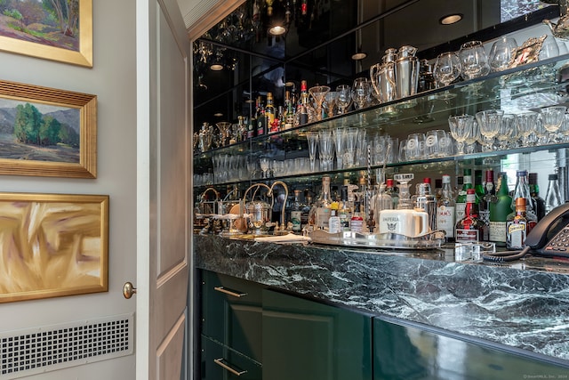 bar featuring radiator heating unit and green cabinetry