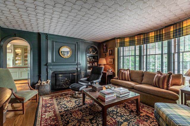 living room with crown molding, hardwood / wood-style flooring, and a fireplace