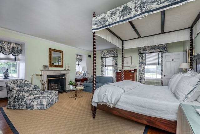 bedroom with crown molding, multiple windows, and hardwood / wood-style flooring