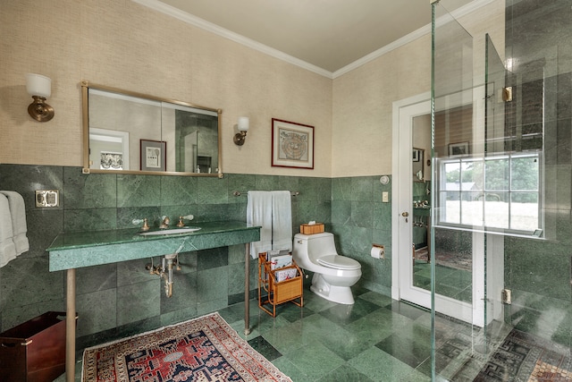 bathroom with crown molding, tile walls, toilet, and sink