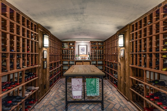 wine cellar featuring a textured ceiling and vaulted ceiling