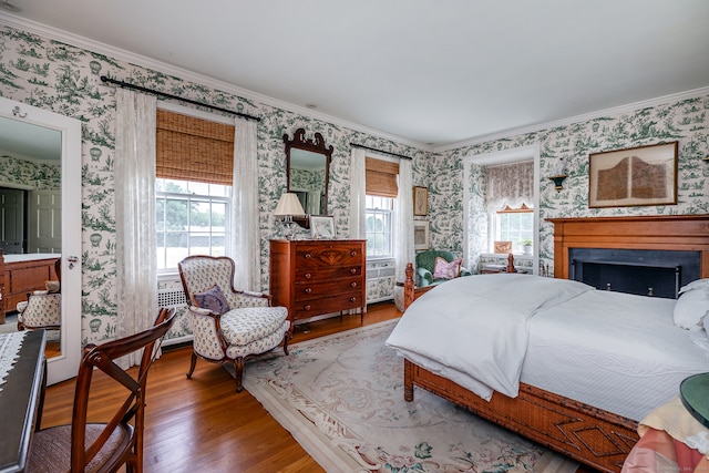 bedroom featuring ornamental molding, multiple windows, and hardwood / wood-style flooring