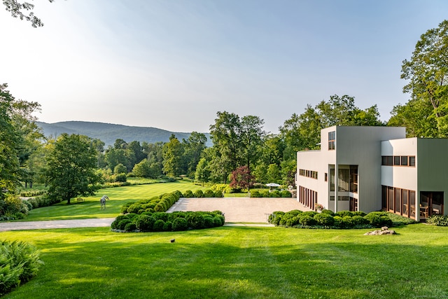 view of property's community with a mountain view and a lawn